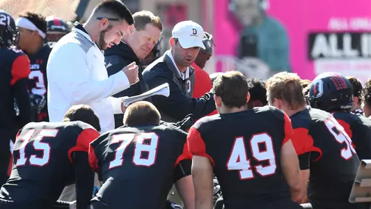 Photo of Coach Nichols in a huddle