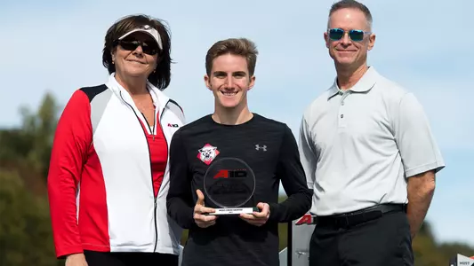Photo of Dylan Carmack on the podium at the A-10 Cross Country Championship