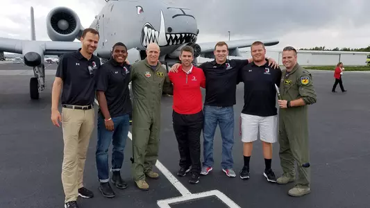 Photo of the football team touring an Air Force A-10 fighter jet