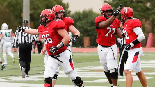 A photo of the offensive line celebrating after a touchdown