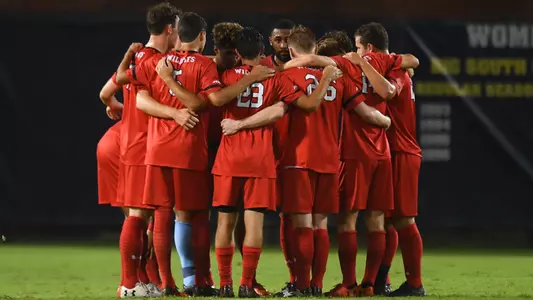 Action photo of men's soccer huddle