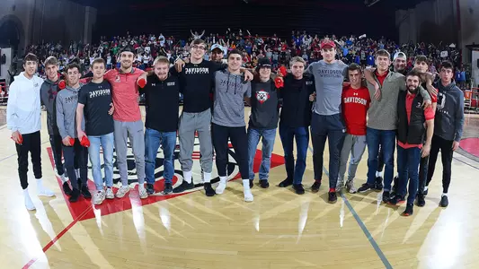 A photo of the wrestling team supporting women's basketball