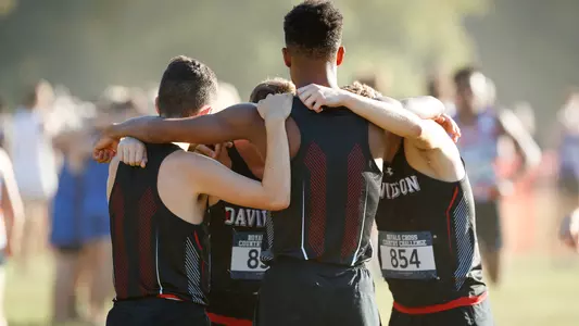 A photo of the 2019 men's cross country team in a huddle