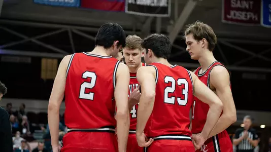 2023-24 team huddle before taking on Fordham in January 2024