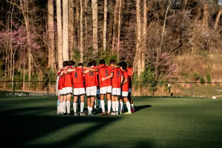 Men's soccer huddles before a spring contest