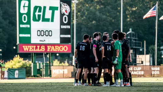 Men's soccer team huddle at Charlotte