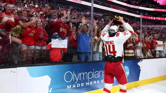 LAS VEGAS, NEVADA - APRIL 11: Rieger Lorenz #14 of the Denver Pioneers raises the championshiop trophy in front of fans during the Division I Men's Ice Hockey Championship held at T-Mobile Arena on April 11, 2026 in Las Vegas, Nevada. (Photo by Tyler Schank/NCAA Photos via Getty Images)