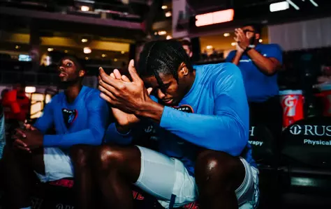eral penn claps his hands together while sitting on DePaul bench pregame