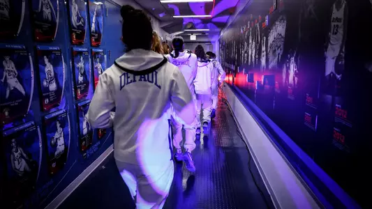 The women's basketball team runs out to the court.