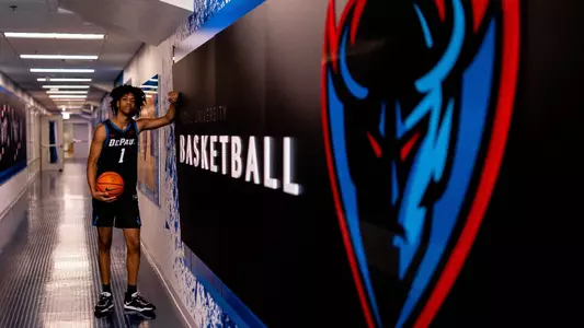 jaden henley leans against wall with DePaul logo and "Basketball"