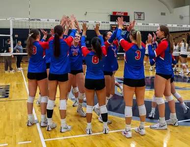 Volleyball team celebrating on court