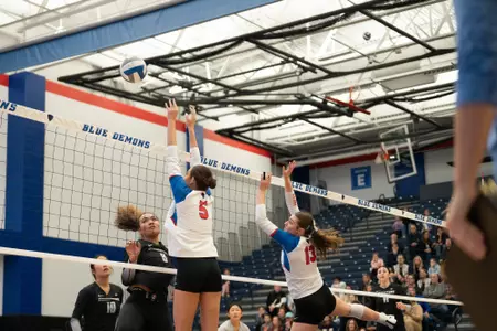 Audrey Klemp and Aly Kindelberger block the volleyball at the net
