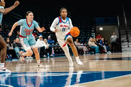 Sumer Lee drives in the middle of the floor, drawing in multiple UIC players.