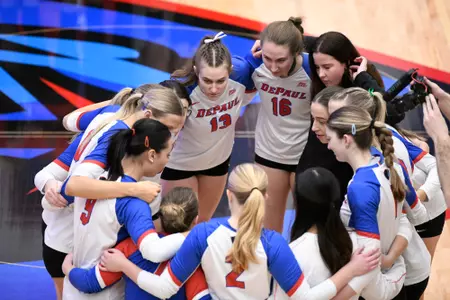 DePaul volleyball huddles on the court