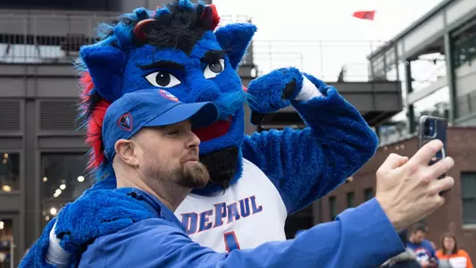 DePaul mascot, DIBS, poses for a selfie with a fan outside of Wrigley Field
