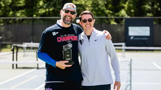 Coach Matt Brothers and Taylor Stapleton holding BIG EAST Trophy