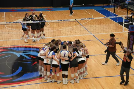 DePaul volleyball huddles on the court