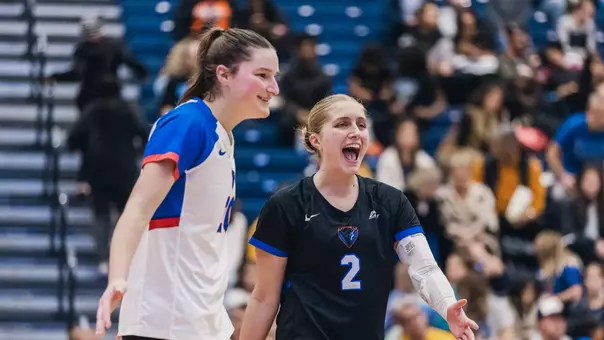 Abby Cahill and Kendall Timme smile after DePaul wins a point