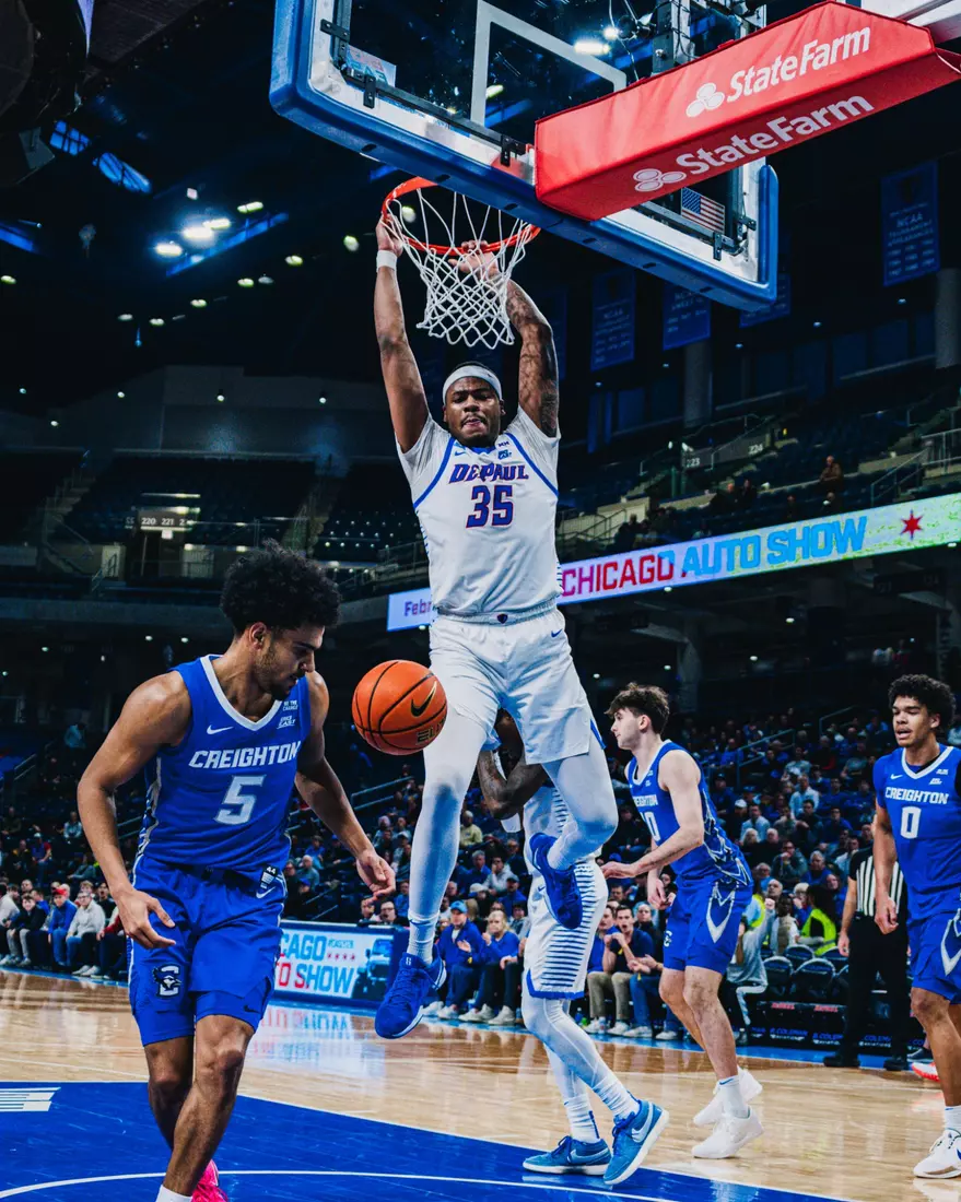 NJ Benson hangs on the rim after bringing down the lob.