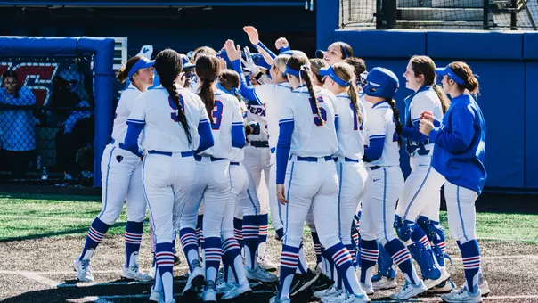 DePaul softball celebrates at the plate after a home run.