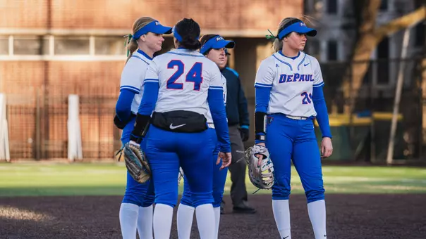 DePaul softball huddles at the pitcher's mound
