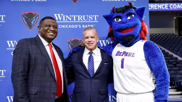 DePaul Men’s Basketball Head Coach Chris Holtmann and DePaul University Vice President and Director of Athletics DeWayne Peevy pose with DePaul's mascot, DIBS