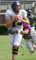 QB Rob Kass (14) tries to elude Marcus Hands during ECU's second scrimmage of the fall Saturday.