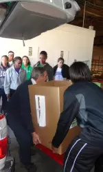 Tatiana Chapple helps carry a box of canned food to donate for Thanksgiving