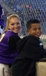 Sophomore Jill Jelnick with ECU's bat boy, Kuola, Tuesday during the Cal State Fullerton game.