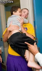 Isaiah Newton, 4, grabs a last-minute hug from ECU's John Wooten