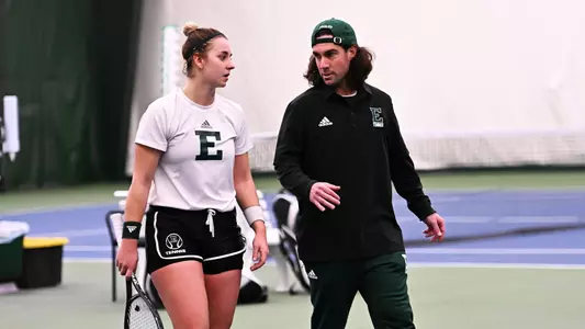 Head Tennis coach Steve Schram provides mentorship during a match in Ypsilanti, March 24