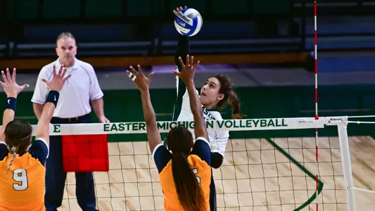 Sabrina Gremm looks to spike on two Toledo players