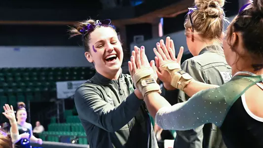 Cassie Bergin high fives teammates during vault rotation against Kent State
