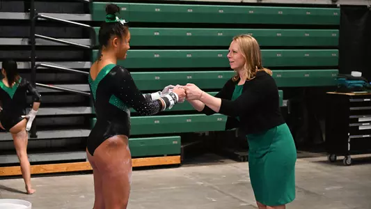 Molly Parris talks with Head Coach Katie Minasola before BGSU bars routine