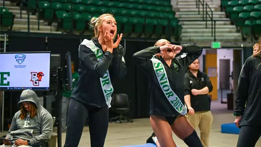 Mayleigh Vanderbeek and Mickayla Stuckey cheer during vault warmups against BGSU
