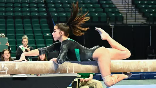 Trinity Macy mounts beam during BGSU meet