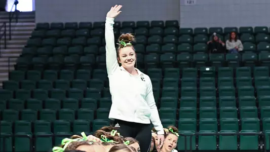 Rai Boris waves at crowd after finishing first on bars against Ball State
