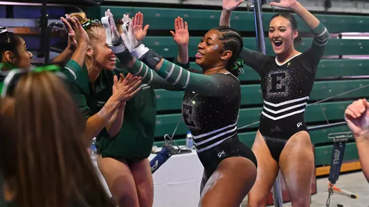 Genae Daniel high fiving teammates after bars