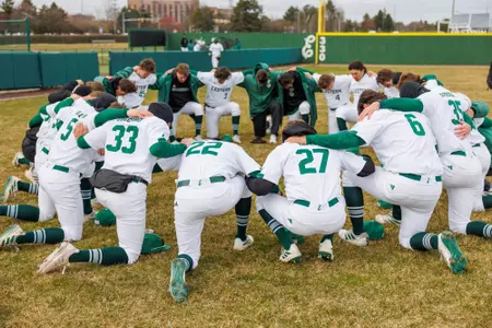Baseball team huddle prior to its game against Michigan, March 19, 2024