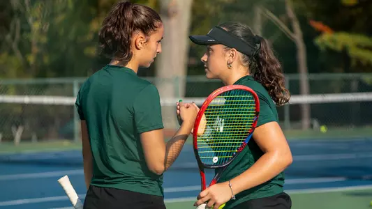 Sabrina Tolstova and Matilde Parreira discuss strategy between points in their doubles match