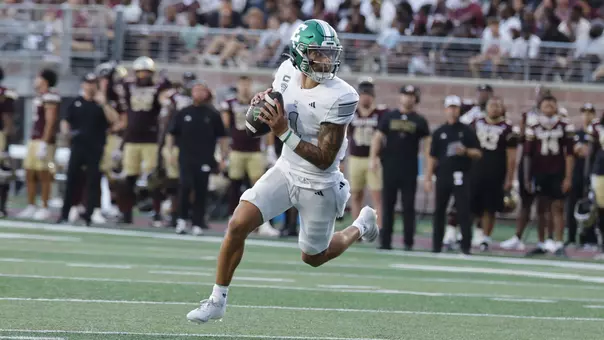 Noah Kim rolls out of the pocket at Texas State, Aug. 30, 2025