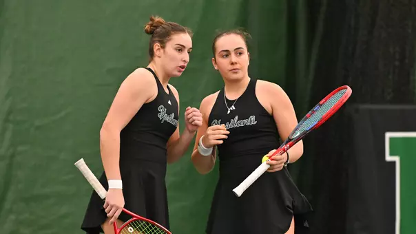 Matilde Parreira and Sabrina Tolstova talk strategy on the court between points of the No. 2 doubles match against Oakland