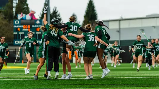 Members of the lacrosse team jump in the air to celebrate at Oregon after defeating the Ducks, 12-9, Feb. 22.