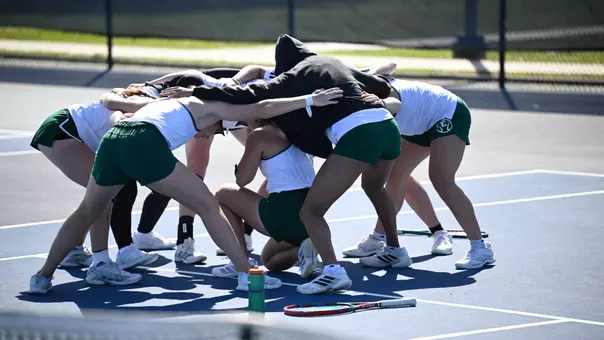 The tennis team huddles on the court ahead of its match with North Florida