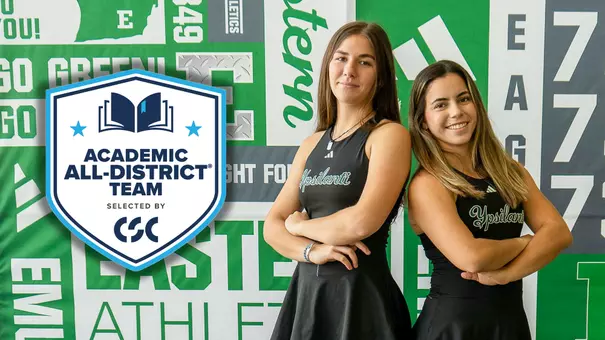 Iva Daneva and Regina Mendez Carreno pose together in front of an EMU banner with the CSC Academic All-District logo appearing to the left of the image