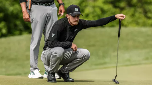 Joshua Hess squats down and studies the green ahead of a putt at the MAC Championships in Zionsville, Ind.