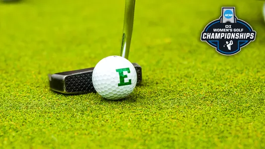 A golf ball with a green Block E logo sits on the putting green in front of the putter head with the 2026 NCAA Division I Women's Golf logo displayed in the top right corner