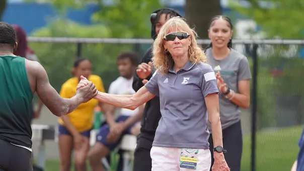 Sue Parks high fives student athlete at 2023 Outdoor MAC Championships