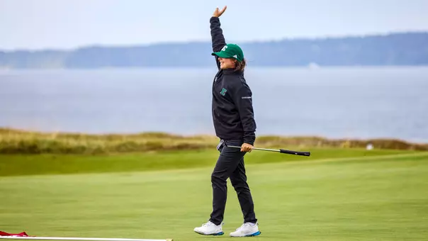 Savannah de Bock waves to her teammates after sinking a putt at Chambers Bay GC, Sept. 14, during the Leadership & Golf Invitational in University Place, Wash.