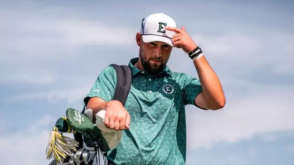 Charlie Box points to the Block E logo on his hat while carrying his back on Whirlwind Golf Course in Chandler, Ariz.